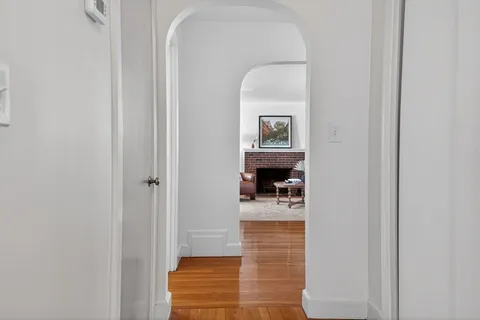 a hallway with a door and a bathroom with sink