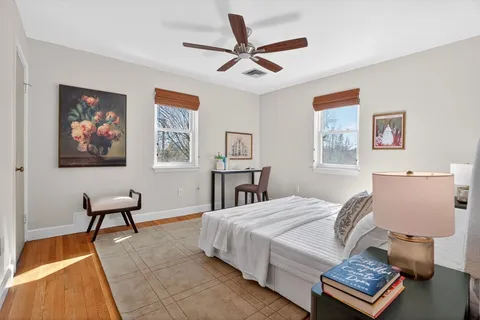 a bedroom with a bed and a chair with a bookshelf