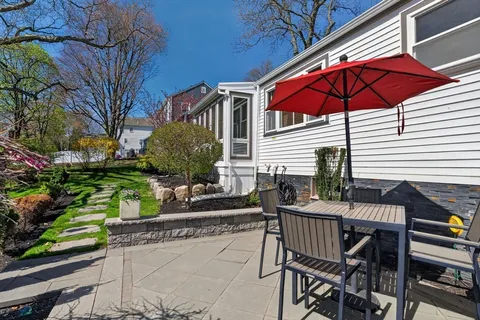 a view of house with backyard and sitting area