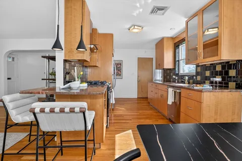 a dining hall with stainless steel appliances granite countertop a stove and a dining table view