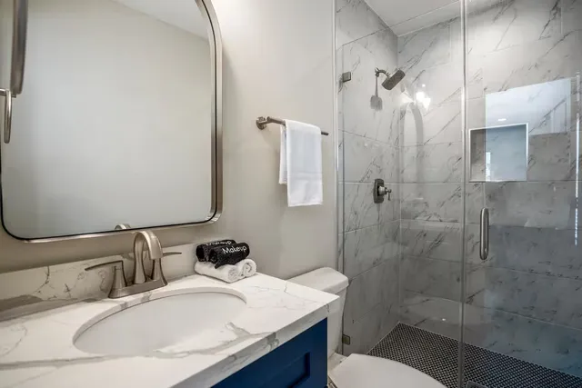 a bathroom with a granite countertop sink toilet and shower