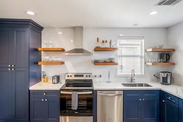 a kitchen with stainless steel appliances a sink a stove and a refrigerator