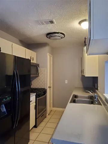 a kitchen with a refrigerator and a sink