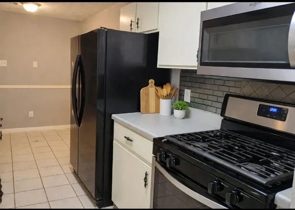 a kitchen with stainless steel appliances granite countertop a refrigerator and a stove top oven