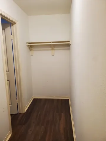 a view of a room with wooden floor and small hallway