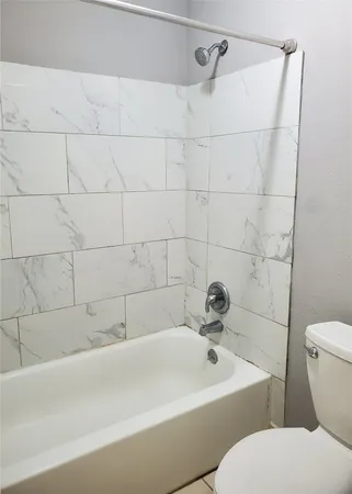 a white bath tub sitting next to a white sink and a toilet