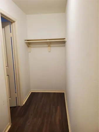 a view of a room with wooden floor and small hallway