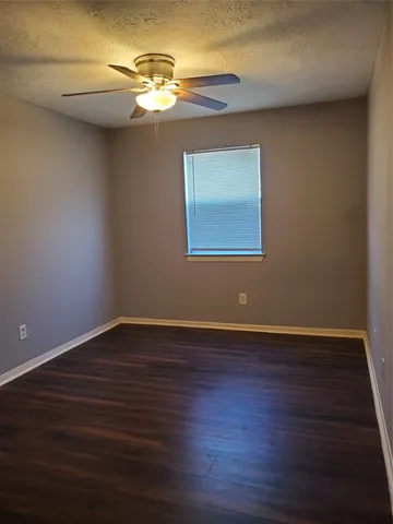 a view of wooden floor and a chandelier fan in a room