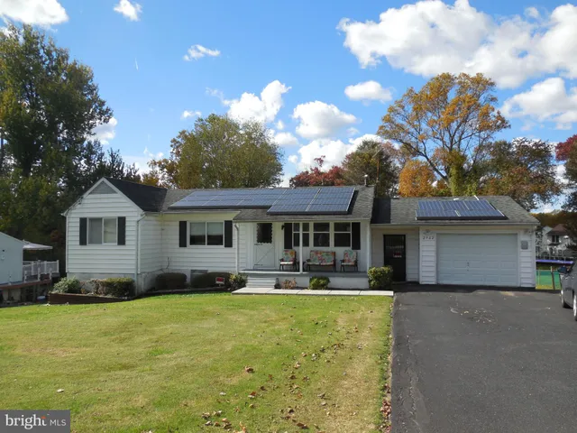 a front view of a house with a yard outdoor seating and garage
