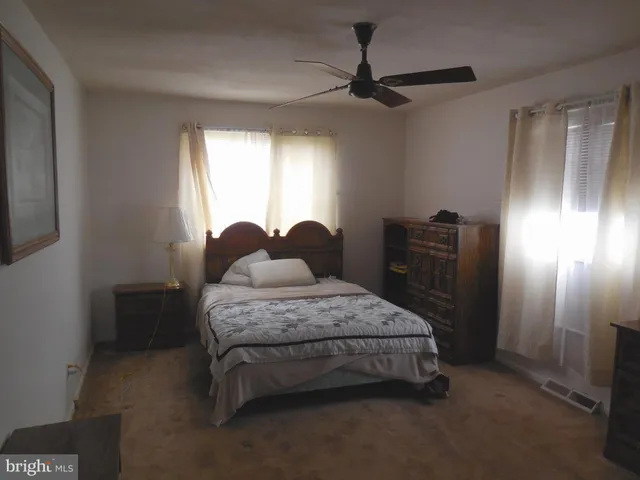 a spacious bedroom with a bed and a chandelier