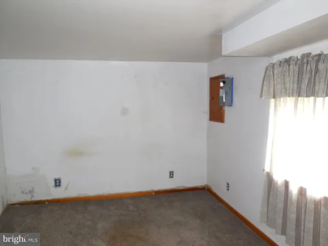 an empty room that has a wooden door and a window