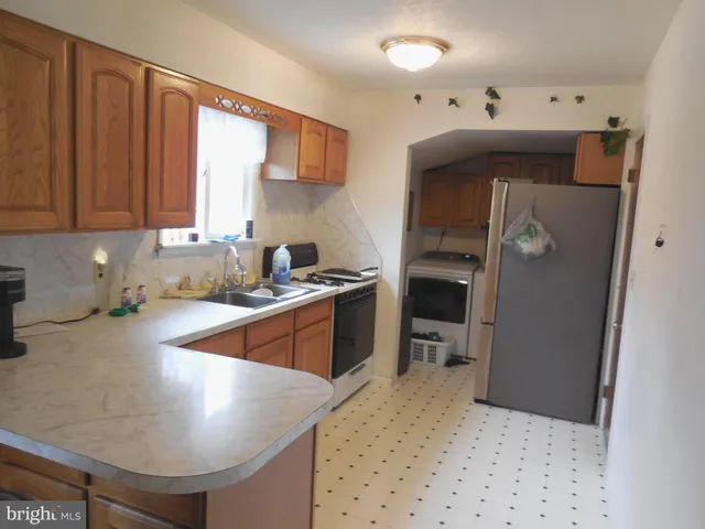 a kitchen with stainless steel appliances granite countertop a sink refrigerator and cabinets