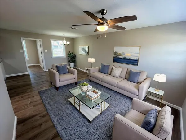 a living room with furniture and a wooden floor