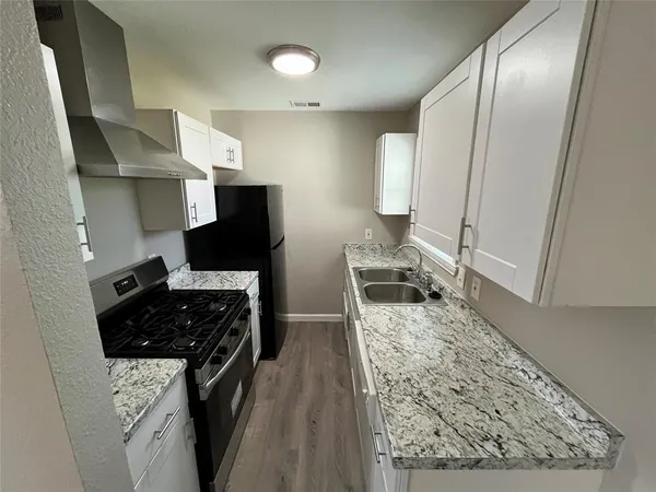a kitchen with sink refrigerator and stove