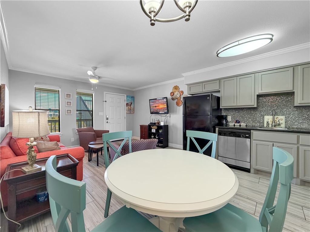 2290 North Fulton Beach Road, Unit 214 Rockport, TX 78382 - Photo 22 of 29 a kitchen with stainless steel appliances a dining table chairs and a refrigerator