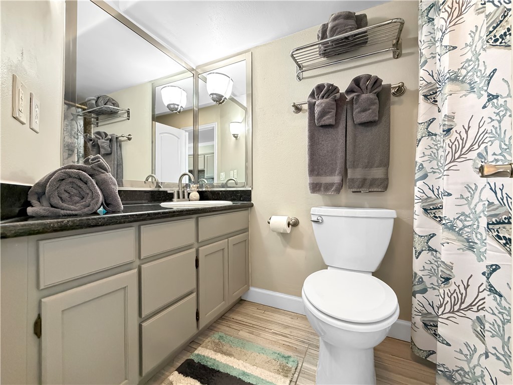 2290 North Fulton Beach Road, Unit 214 Rockport, TX 78382 - Photo 25 of 29 a bathroom with a toilet sink and mirror