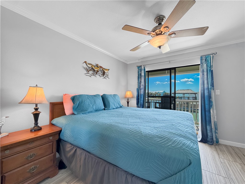 2290 North Fulton Beach Road, Unit 214 Rockport, TX 78382 - Photo 27 of 29 a bedroom with a large bed and a chandelier