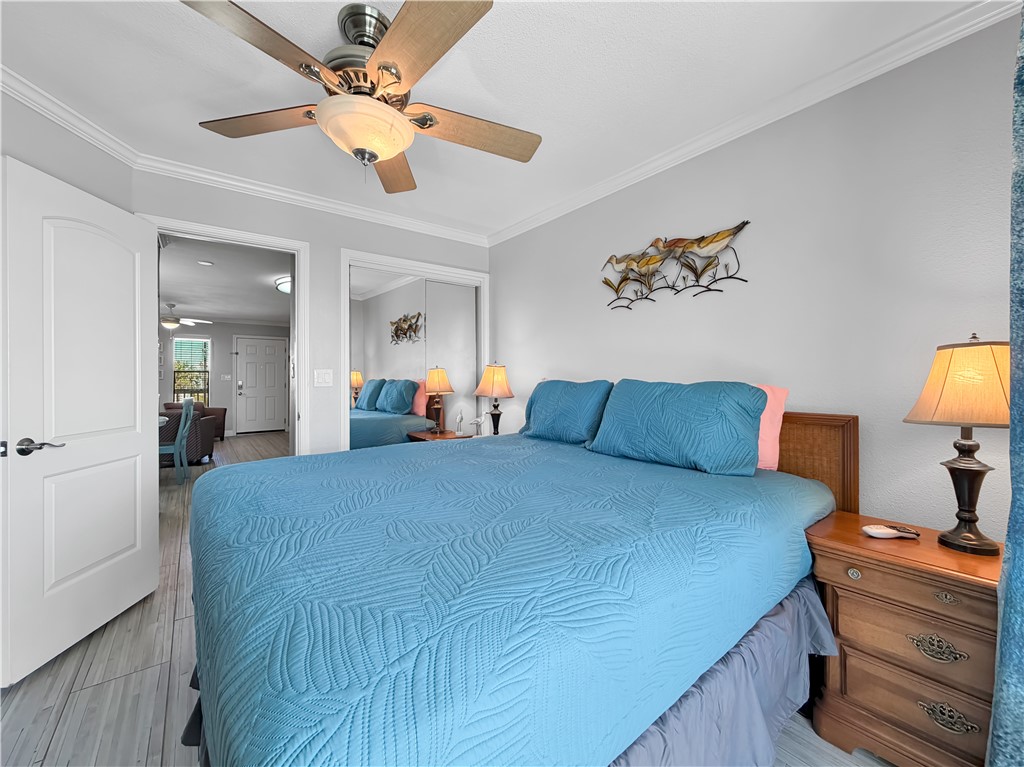 2290 North Fulton Beach Road, Unit 214 Rockport, TX 78382 - Photo 28 of 29 a bedroom with a bed and a chandelier