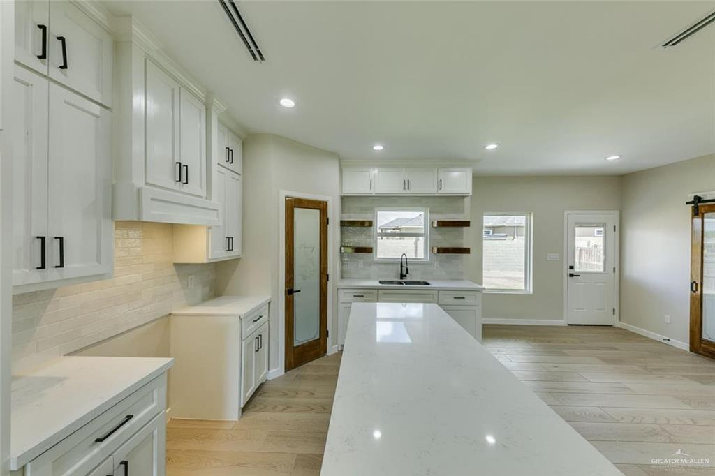 910 Trinity Street Alamo, TX 78516 - Photo 6 of 12 a kitchen with stainless steel appliances kitchen island granite countertop a sink refrigerator and cabinets