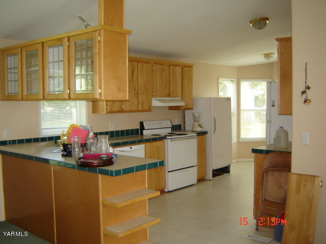 9205 Duffield Road Moxee, WA 98936 - Photo 2 of 5 a kitchen with stainless steel appliances granite countertop a sink cabinets and a window