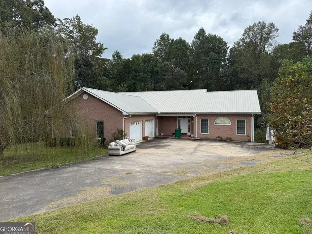 a view of a house with backyard and trees
