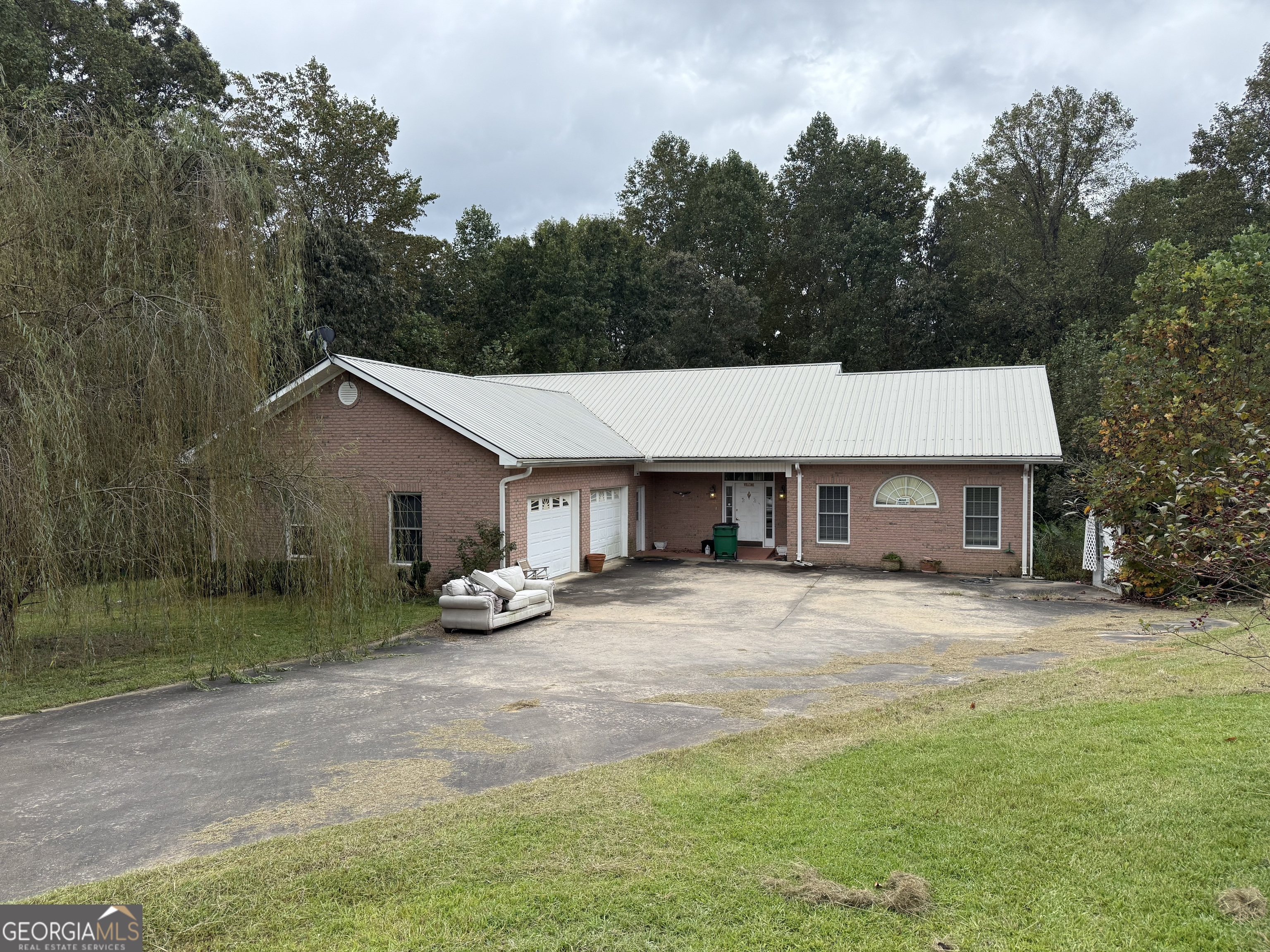 a view of a house with backyard and trees