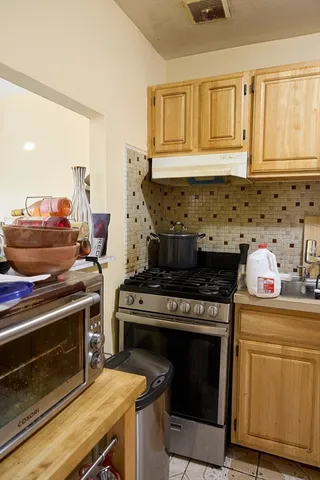 a kitchen stove sitting inside of a kitchen with granite countertop a stove top oven