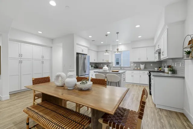a living room with furniture and a dining table with kitchen view