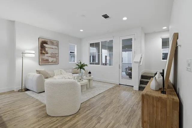 a living room with furniture and a table with wooden floor