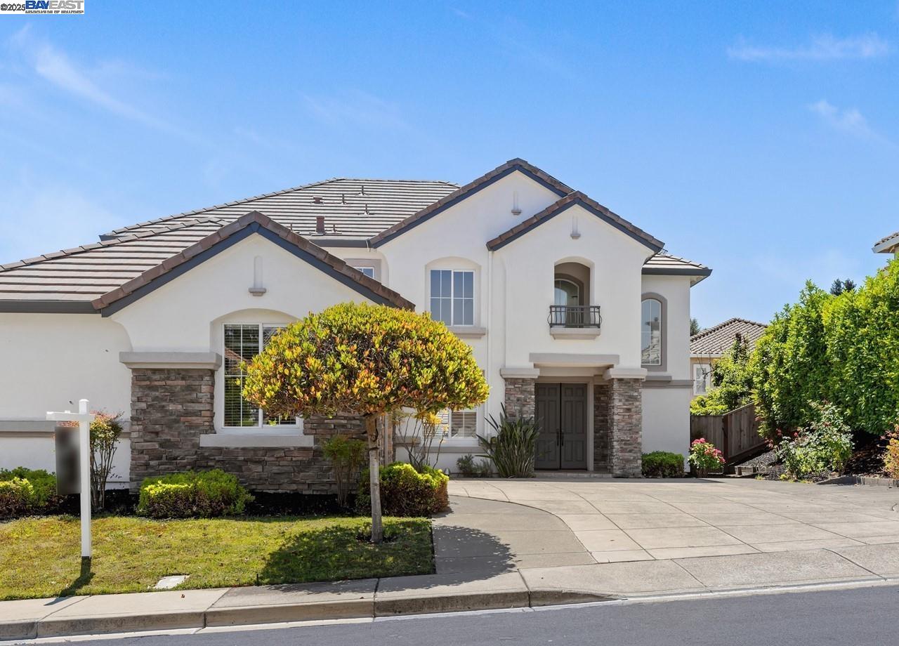 a front view of a house with a garden and plants