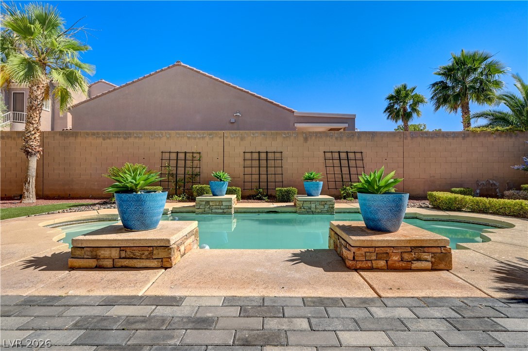 2793 Rosenhearty Drive Henderson, NV 89044 - Photo 65 of 85 This tranquil backyard oasis features a shimmering pool, surrounded by well-maintained landscaping and a privacy wall.