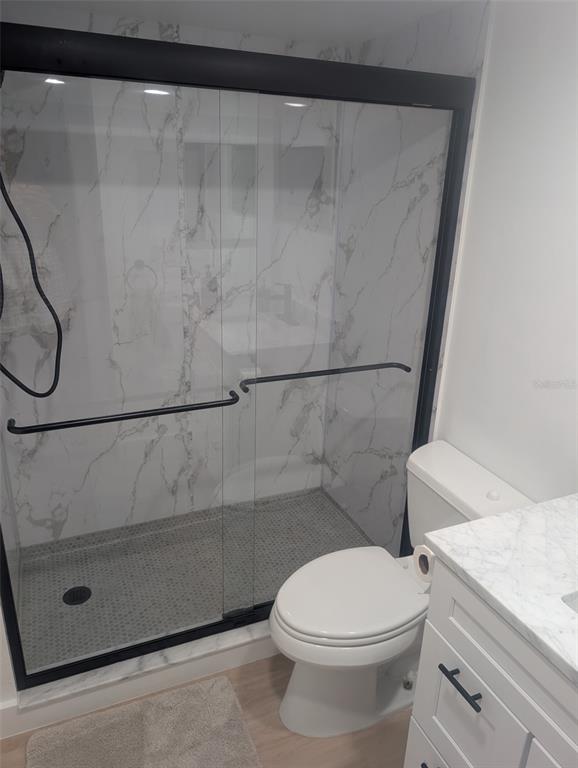4725 Cove Circle, Unit 405 St. Petersburg, FL 33708 - Photo 13 of 23 a white toilet sitting next to a shower