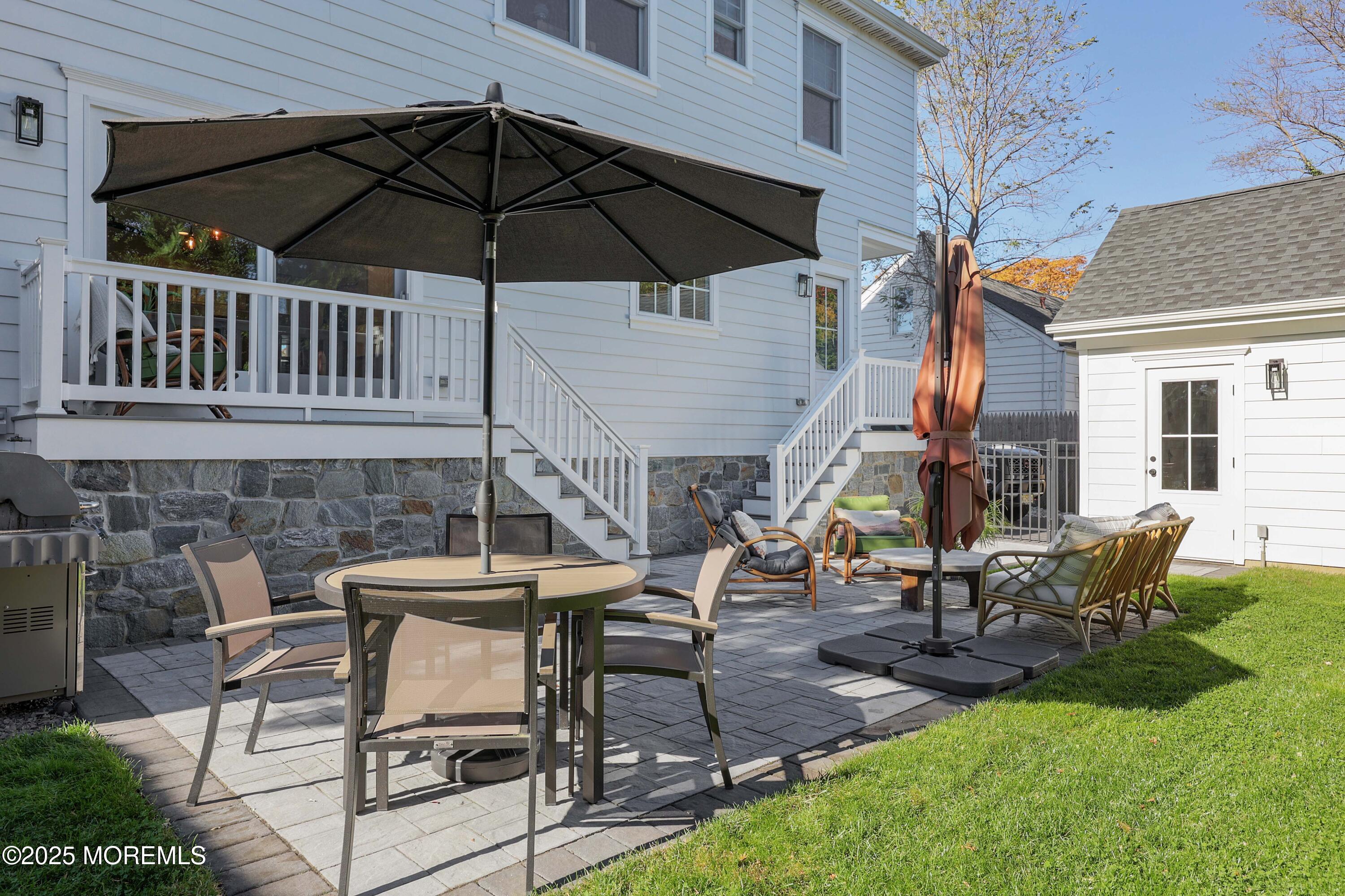 41 Forrest Avenue Rumson, NJ 07760 - Photo 25 of 32 a view of a backyard with table and chairs under an umbrella