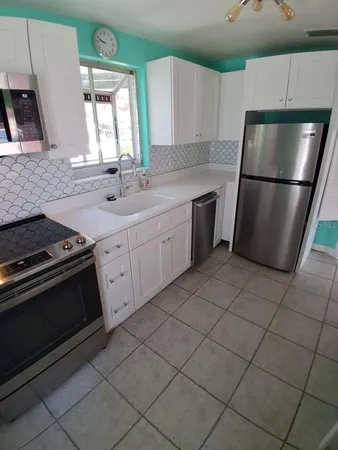 a kitchen with a sink stove and refrigerator