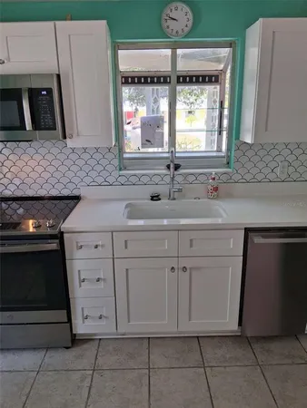 a kitchen with white cabinets and a sink