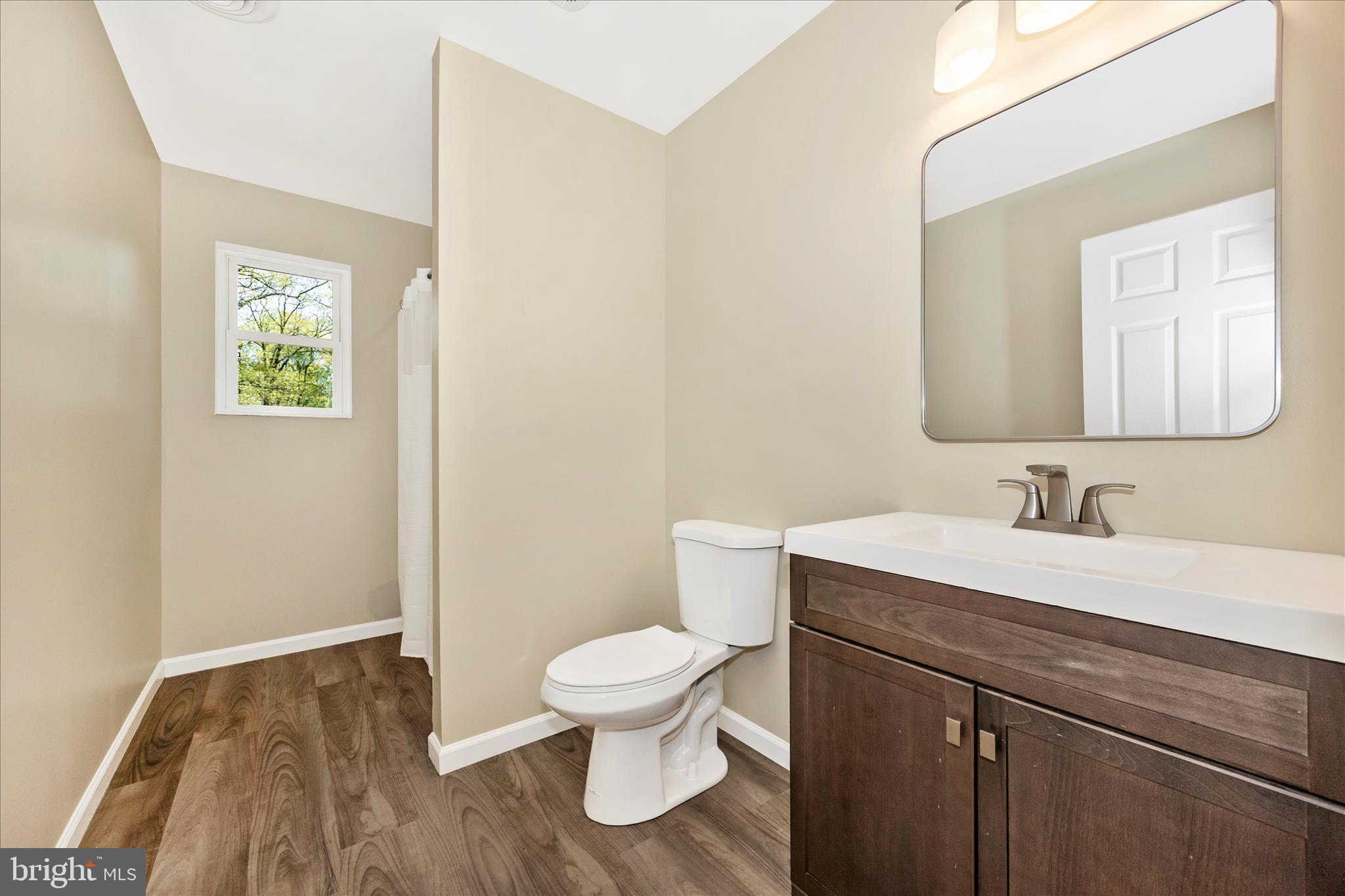 6518 Woodville Road Mount Airy, MD 21771 - Photo 32 of 53 a bathroom with a toilet a sink and mirror
