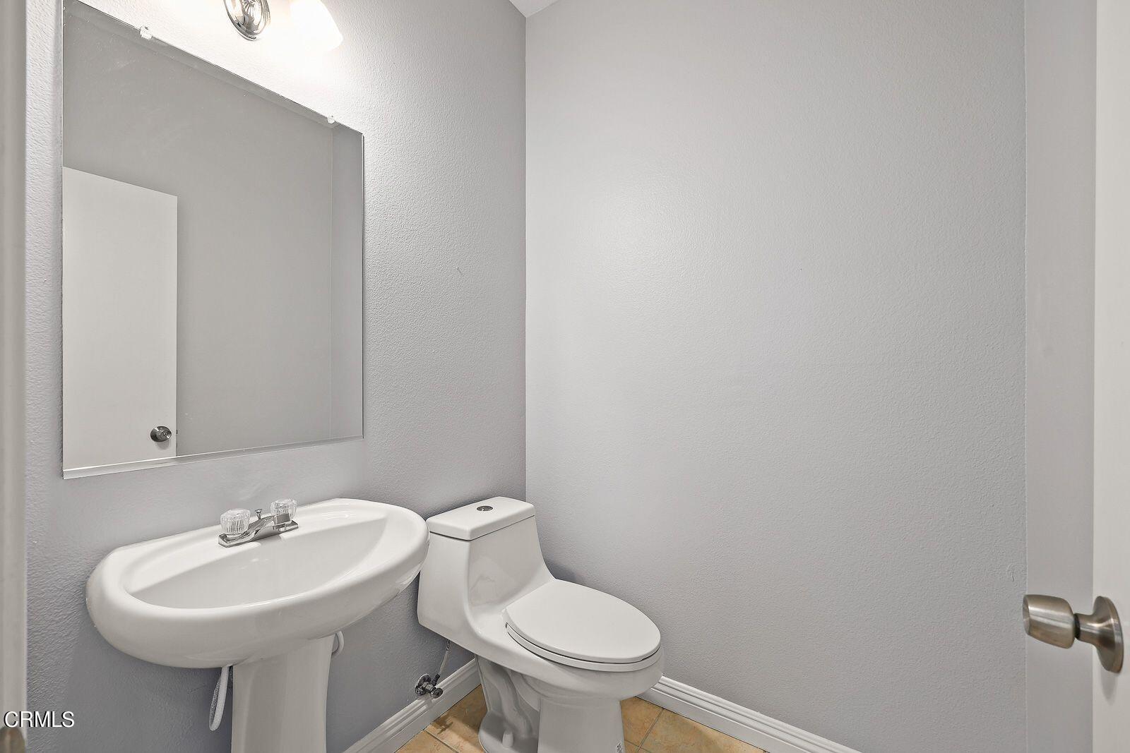 16740 Inverrary Way Fontana, CA 92336 - Photo 12 of 29 a bathroom with a sink a toilet and a mirror