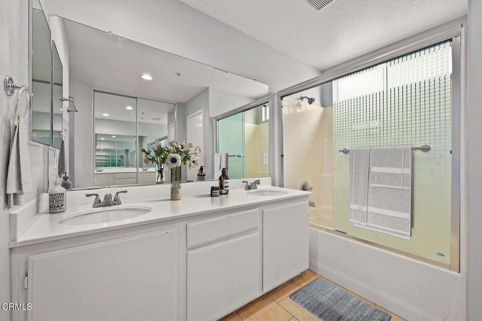 16740 Inverrary Way Fontana, CA 92336 - Photo 17 of 29 a bathroom with a double vanity sink and mirror