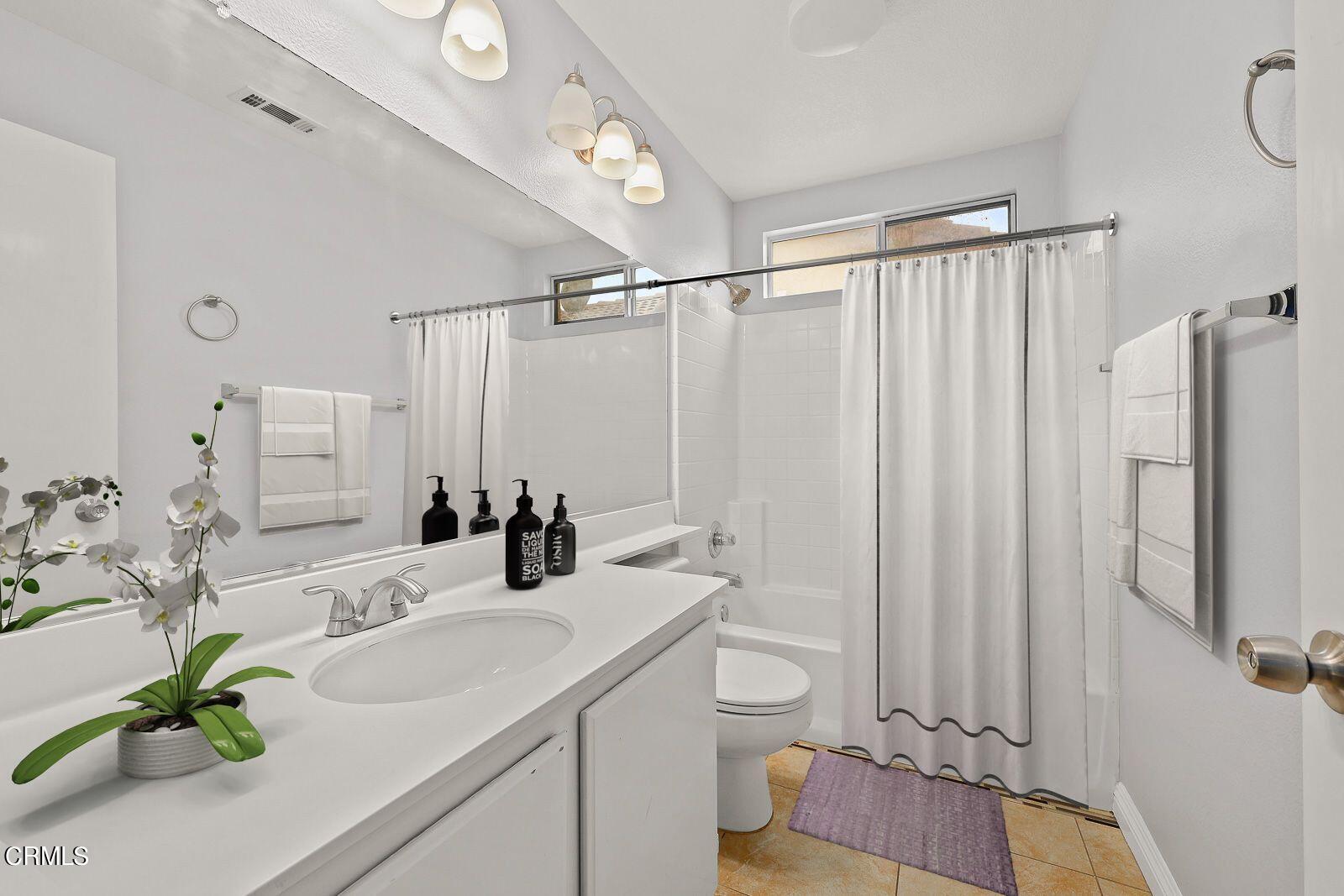 16740 Inverrary Way Fontana, CA 92336 - Photo 20 of 29 a bathroom with a double vanity sink and a mirror
