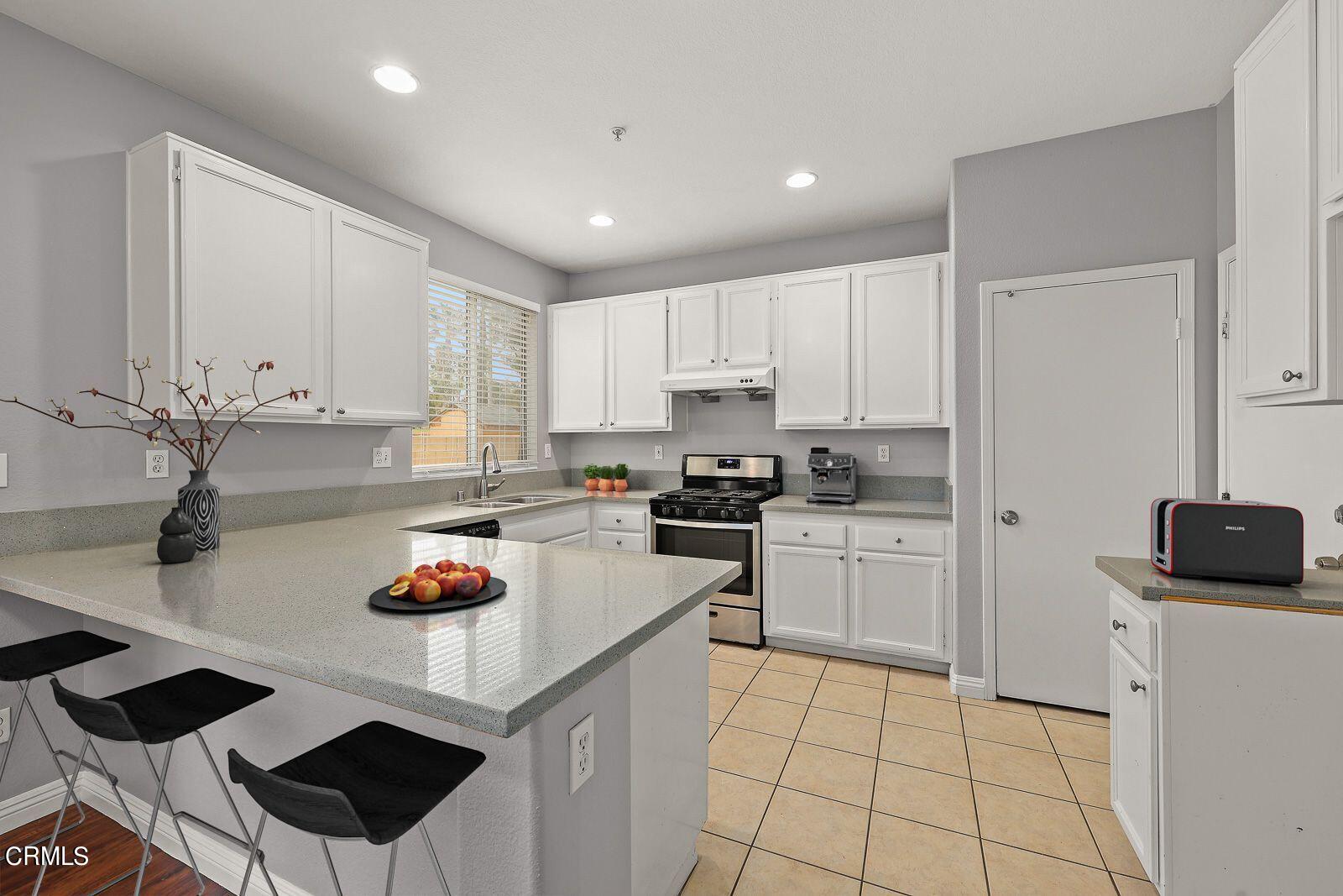 16740 Inverrary Way Fontana, CA 92336 - Photo 8 of 29 a kitchen with a sink a stove and cabinets