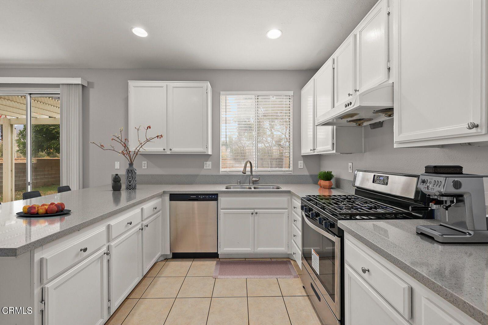 16740 Inverrary Way Fontana, CA 92336 - Photo 9 of 29 a kitchen with cabinets appliances a sink and a counter top space