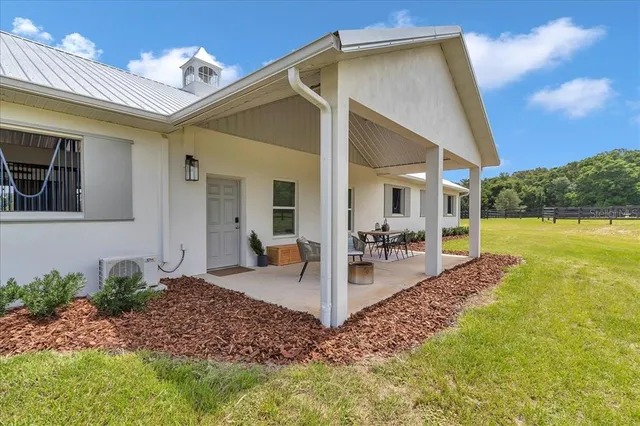 a view of a house with backyard and sitting area