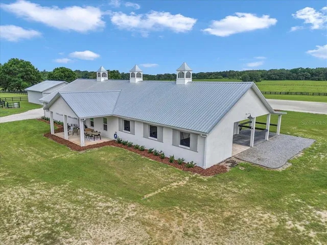 an aerial view of residential houses with outdoor space and trees