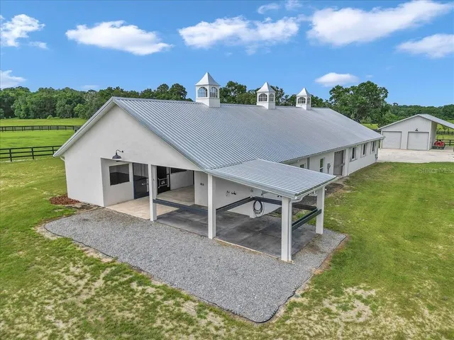 a aerial view of a house next to a yard and large tree