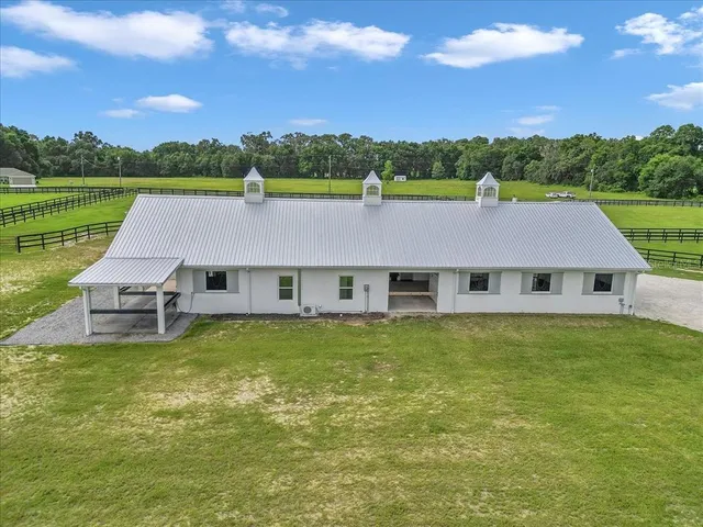 a view of a house with a big yard and large trees