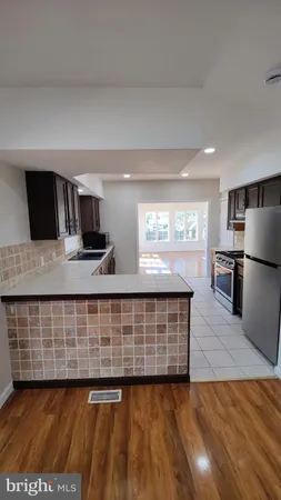 a kitchen with stainless steel appliances wooden floors and wooden cabinets
