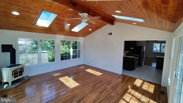 a view of empty room with wooden floor and fireplace