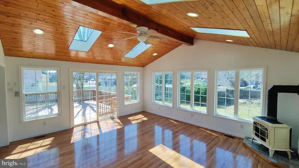 a living room with furniture large windows and wooden floor