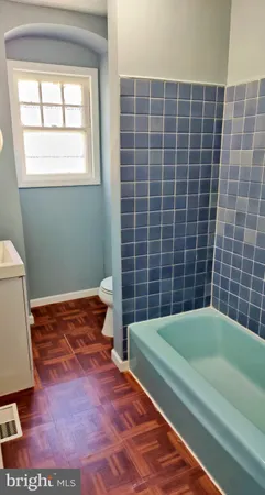 a bathroom with a tub and a toilet