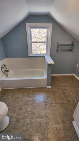 a view of bathroom with bathtub and window